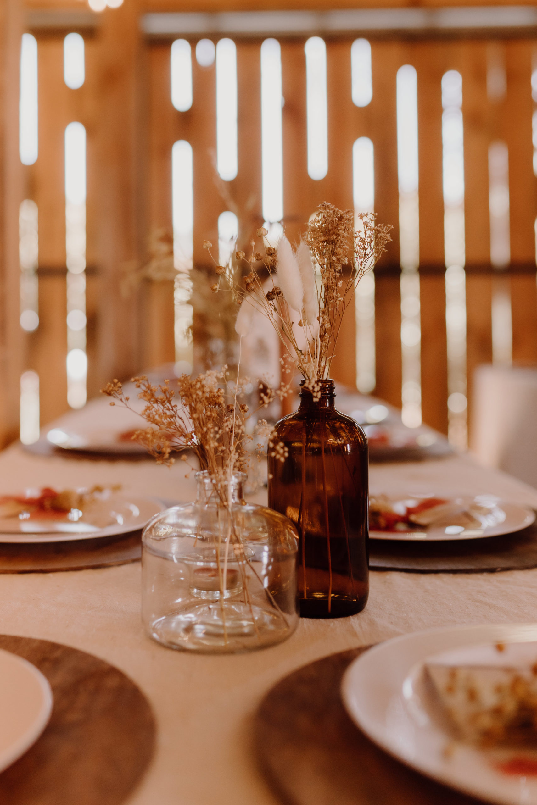 terracotta colored glass bottle center piece with dried florals