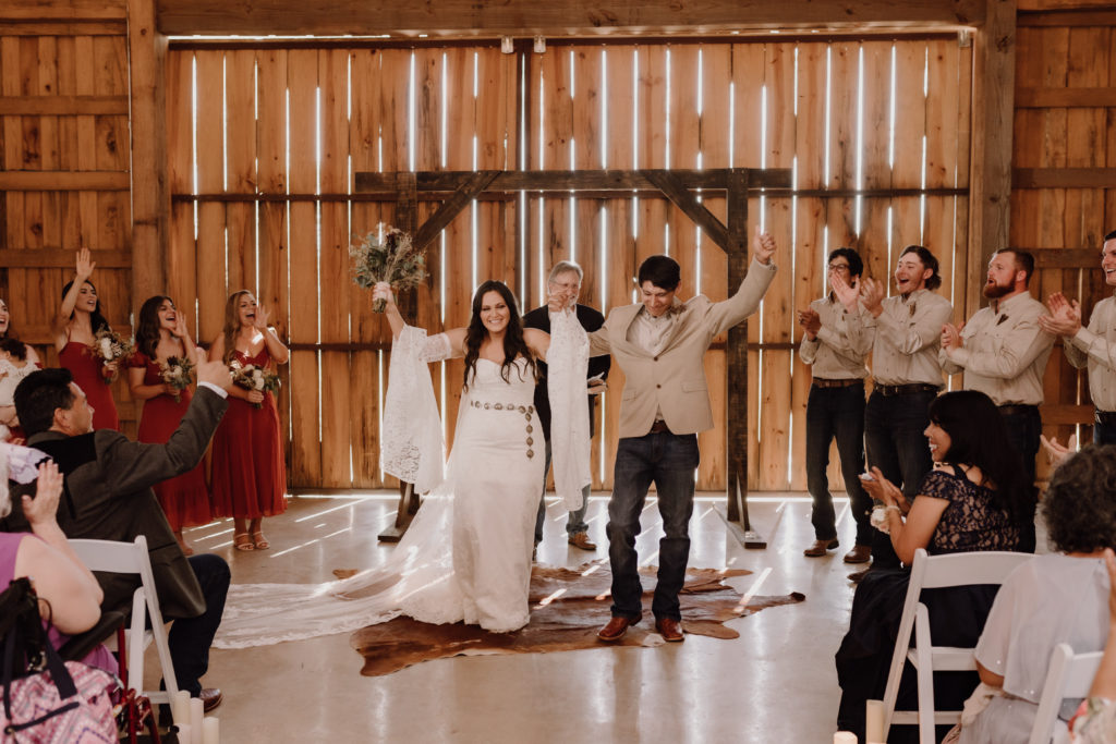 Bride and groom kiss at alter during their boho wedding ceremony 